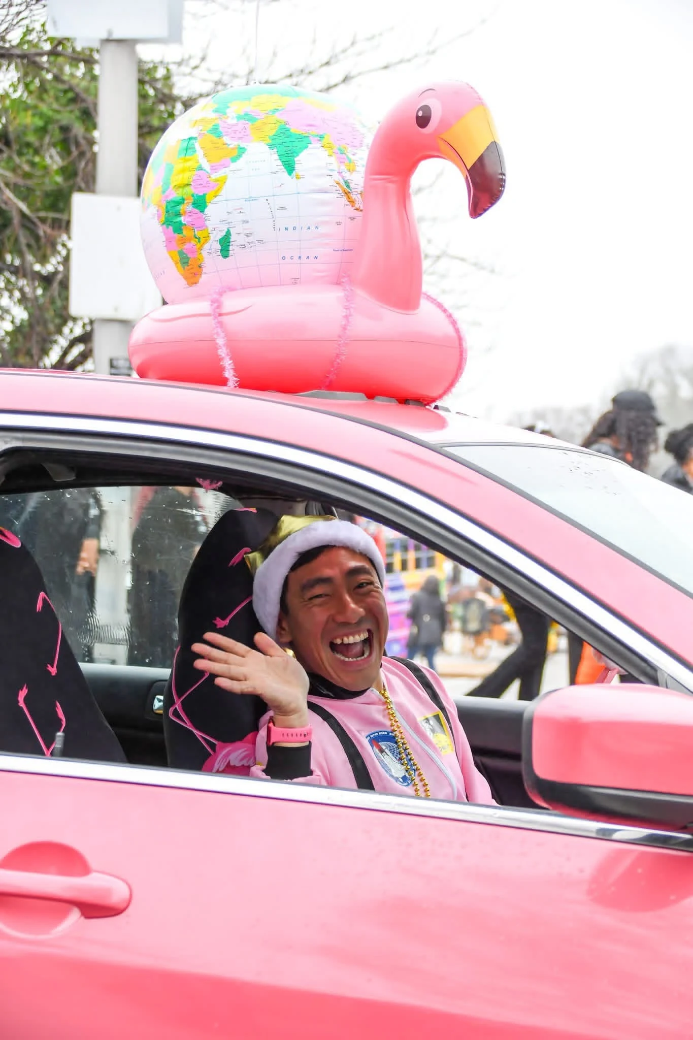 Yong waving from his pink car at a parade